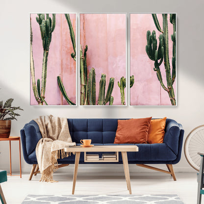 Framed canvas of tall green cacti against a soft pink wall, ideal for modern desert or colorful southwest-inspired home decor.