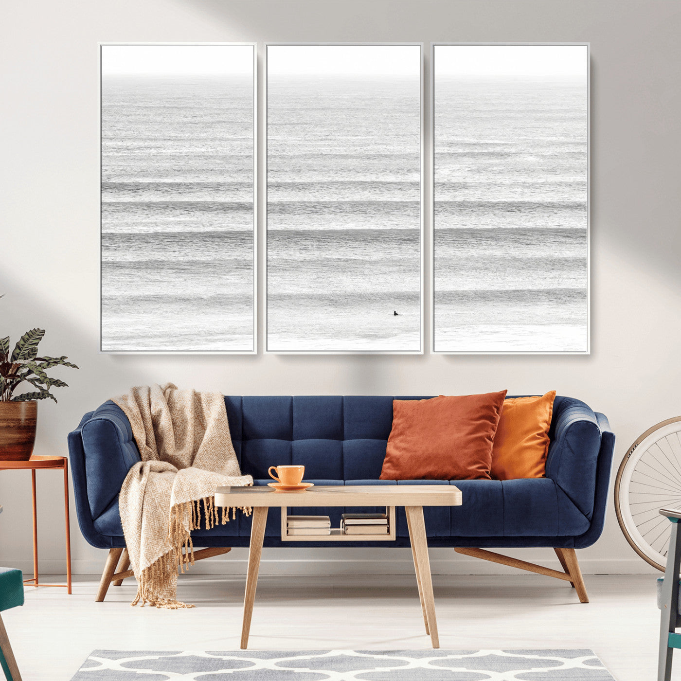 Monochrome photo of a lone surfer in calm layered waves, perfect for minimalist coastal or moody ocean-inspired wall decoration.