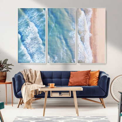 Aerial photo of soft blue waves meeting sandy shore, perfect for modern coastal or beach-themed decor with a light and tranquil aesthetic.