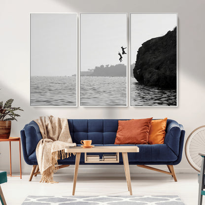 Black and white canvas of two figures cliff jumping into the sea, captured with moody tones, ideal for modern coastal or adventure-themed home decor.   2/2