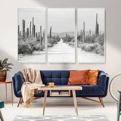 A black and white desert road stretching through a cactus-filled landscape, creating a rugged and timeless southwestern aesthetic with a sense of adventure.