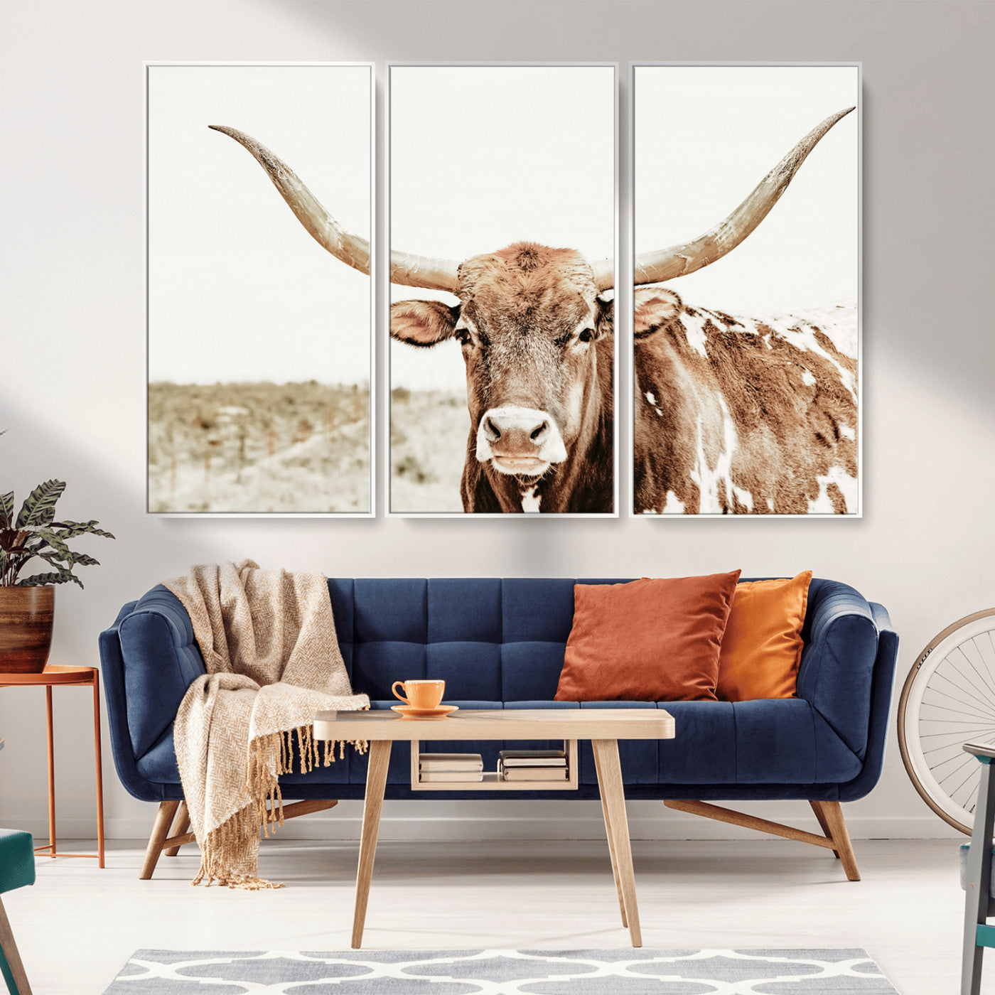 A Texas longhorn bull with wide horns, standing in a dry field under soft light, ideal for rustic farmhouse or western-themed interiors.