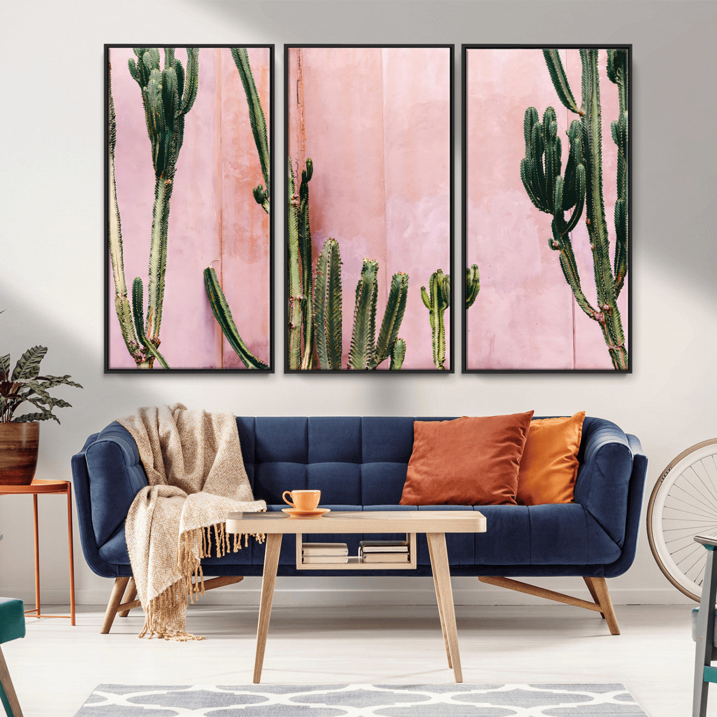 Framed canvas of tall green cacti against a soft pink wall, ideal for modern desert or colorful southwest-inspired home decor.