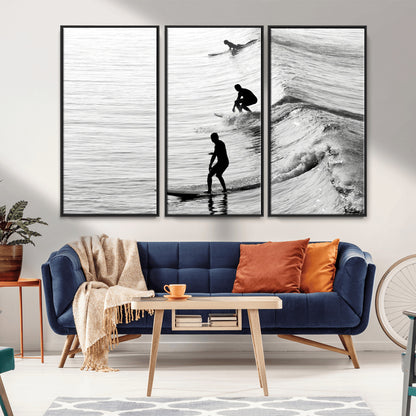 Black and white photo of surfers riding waves in a moody, high-contrast scene, ideal for modern coastal or surf-inspired home decor.