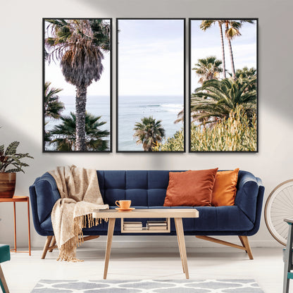 Scenic coastal view with tall palm trees overlooking a calm ocean, soft blue waves, and surfers in the distance, creating a peaceful tropical vibe.
