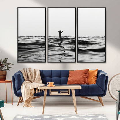 Black and white ocean with a hand making a surfer sign among dark waves, creating a dramatic and minimalist seascape with bold contrast.