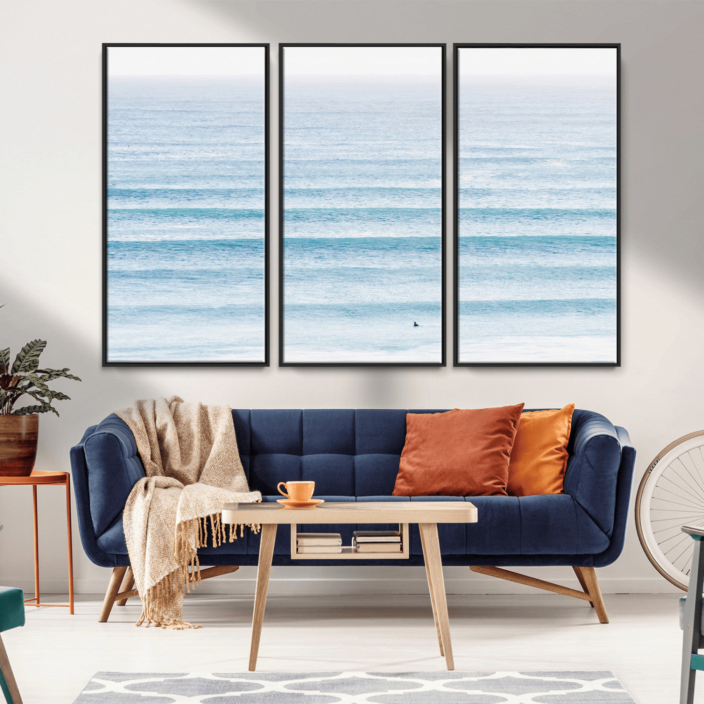 Minimalist ocean view with soft blue waves and a lone surfer, creating a serene and airy coastal aesthetic, perfect for tranquil home decor.