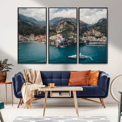 Aerial view of Amalfi Coast, Italy, with colorful hillside houses, lush green mountains, and a luxury yacht sailing in turquoise waters.