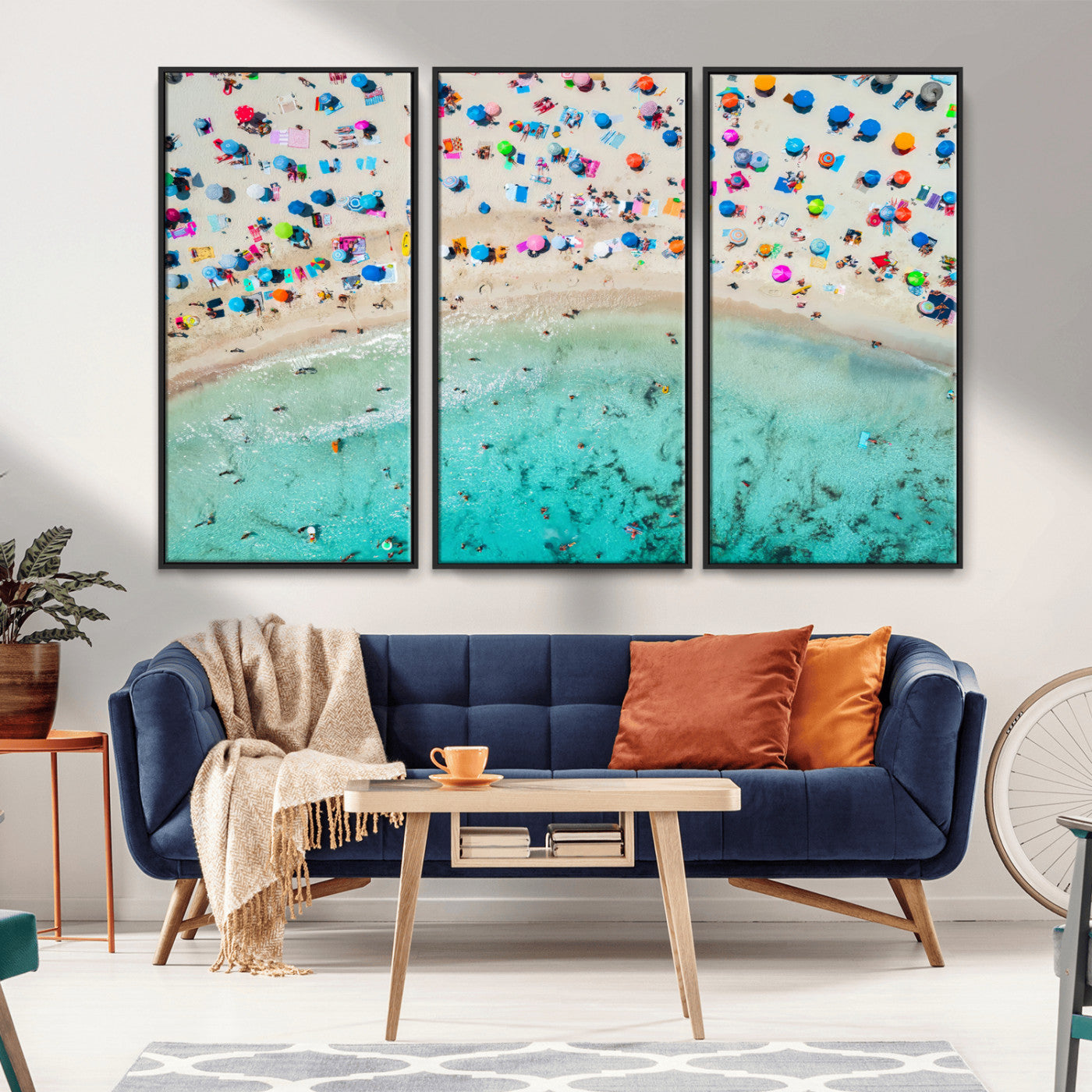 Aerial view of a vibrant beach filled with colorful umbrellas and people enjoying the turquoise ocean, capturing a lively summer vacation scene.