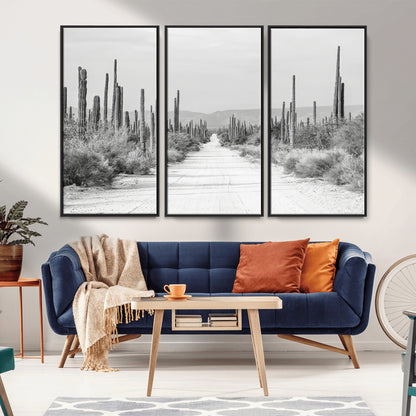 A black and white desert road stretching through a cactus-filled landscape, creating a rugged and timeless southwestern aesthetic with a sense of adventure.
