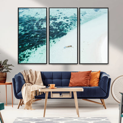 Canvas featuring an aerial view of a swimmer in shallow turquoise waters with coral patterns, ideal for tropical coastal home decor.