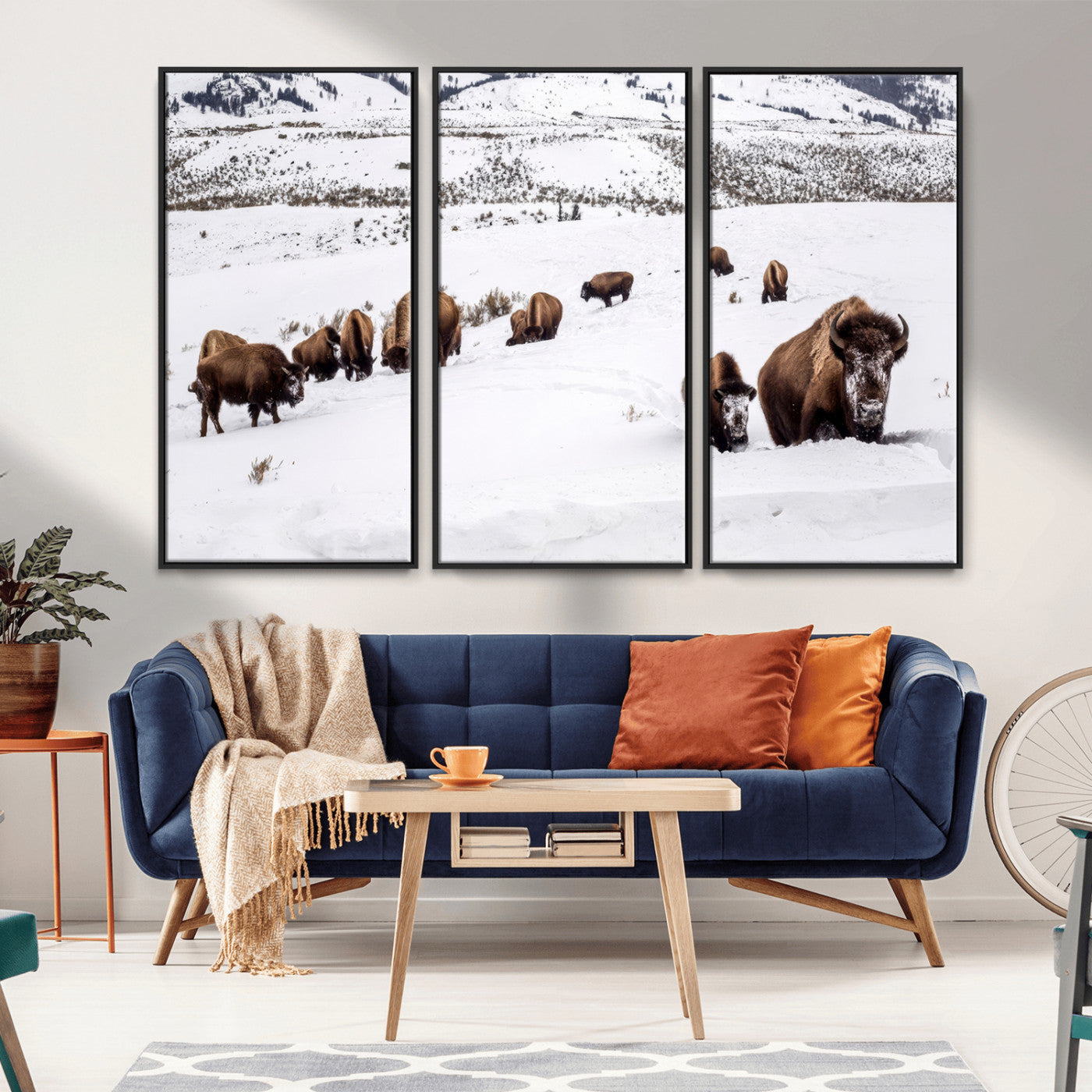 A herd of bison walking through deep snow in a mountain valley, perfect for rustic, cabin or western-themed wall decor.