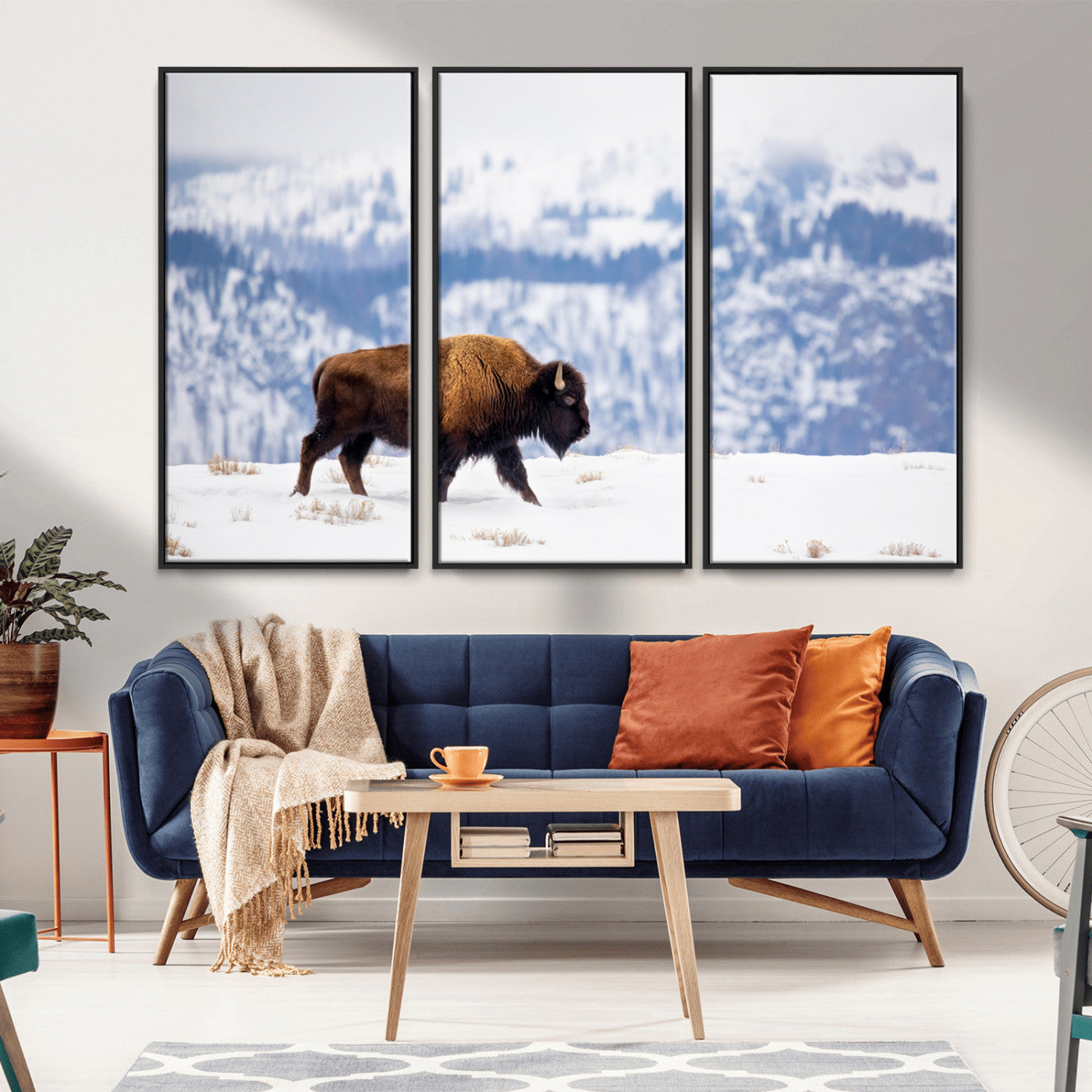 A lone bison walks across snowy ground with blue-toned mountain range behind, ideal for rustic or western farmhouse interiors.