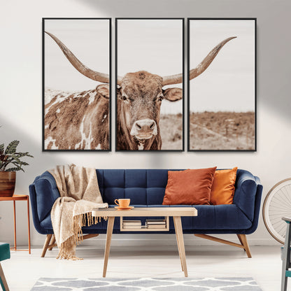 A longhorn cow in soft beige desert tones, standing calmly in open land, perfect for neutral western or rustic farmhouse interiors.