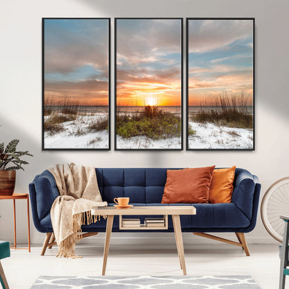 A tranquil beach scene featuring golden sunset hues over the water, with grasses in the foreground and a peaceful, serene atmosphere.