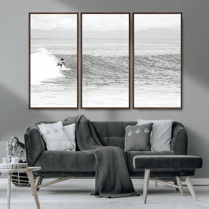 Monochrome photo of a surfer riding a wave with distant mountains, ideal for coastal motion or black and white surf-themed wall decor.