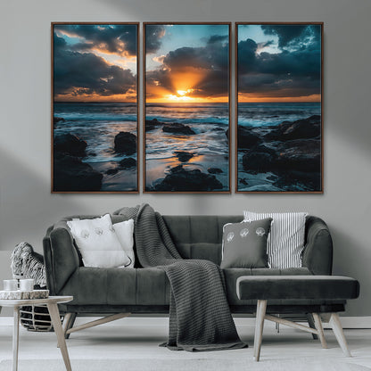 An awe-inspiring sunset over the ocean with rays of light piercing through dramatic clouds, creating a beautiful seascape with rocks in the foreground.