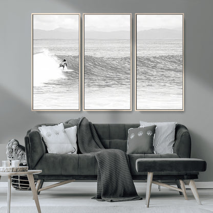 Monochrome photo of a surfer riding a wave with distant mountains, ideal for coastal motion or black and white surf-themed wall decor.