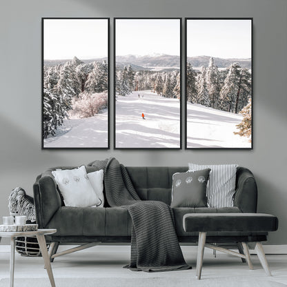 Bright ski trail lined with snow-covered pines and a skier in orange, perfect for alpine adventure or winter sports-inspired decor.