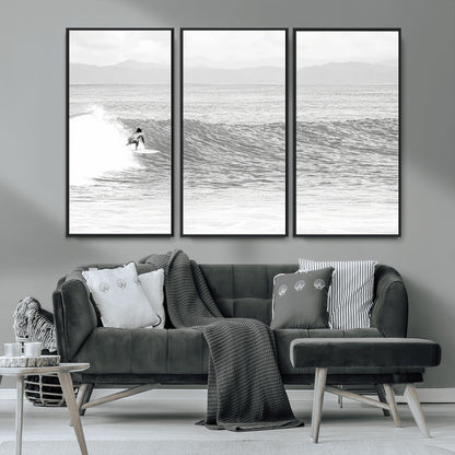 Monochrome photo of a surfer riding a wave with distant mountains, ideal for coastal motion or black and white surf-themed wall decor.
