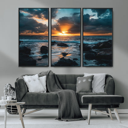 An awe-inspiring sunset over the ocean with rays of light piercing through dramatic clouds, creating a beautiful seascape with rocks in the foreground.
