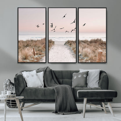 A peaceful coastal pathway leading to the ocean, with birds flying across a soft pastel sky, creating a calm and scenic beach atmosphere.