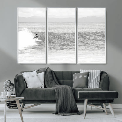 Monochrome photo of a surfer riding a wave with distant mountains, ideal for coastal motion or black and white surf-themed wall decor.