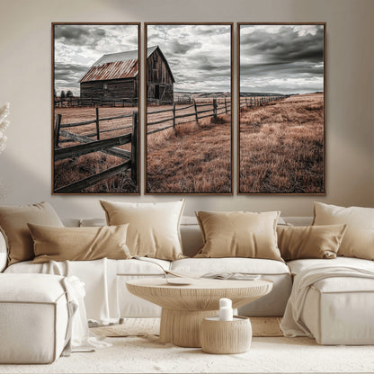Framed canvas of a rustic barn under a moody sky with weathered fence and dark fields, ideal for farmhouse or rural-style wall decor.