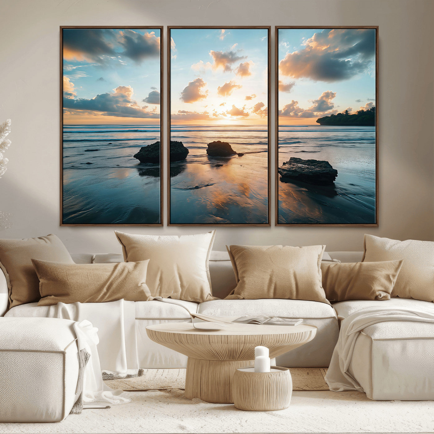 A serene beach at sunset with vibrant clouds, calm water, and rocks in the foreground reflecting the warm colors of the setting sun.