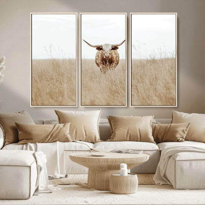 Texas Longhorn bull standing alone in dry grass with neutral tones, ideal for rustic western or cowboy-themed wall decor.