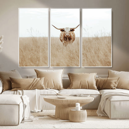 Texas Longhorn bull standing alone in dry grass with neutral tones, ideal for rustic western or cowboy-themed wall decor.