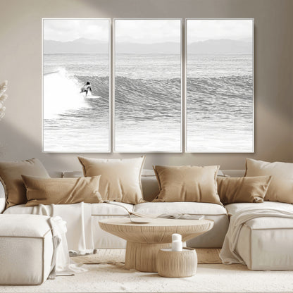 Monochrome photo of a surfer riding a wave with distant mountains, ideal for coastal motion or black and white surf-themed wall decor.