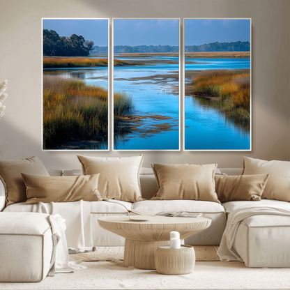 A peaceful marshland scene with calm blue water reflecting the surrounding grasses and trees, capturing the beauty of nature in a serene landscape.