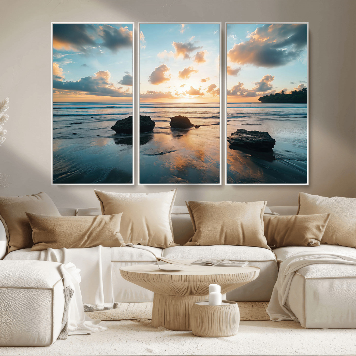 A serene beach at sunset with vibrant clouds, calm water, and rocks in the foreground reflecting the warm colors of the setting sun.