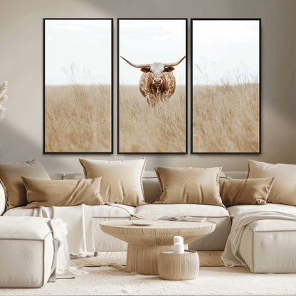 Texas Longhorn bull standing alone in dry grass with neutral tones, ideal for rustic western or cowboy-themed wall decor.