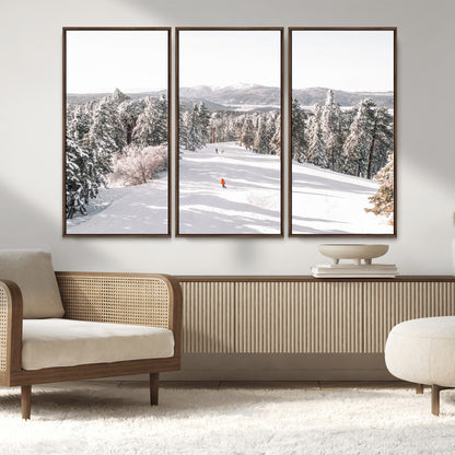 Bright ski trail lined with snow-covered pines and a skier in orange, perfect for alpine adventure or winter sports-inspired decor.