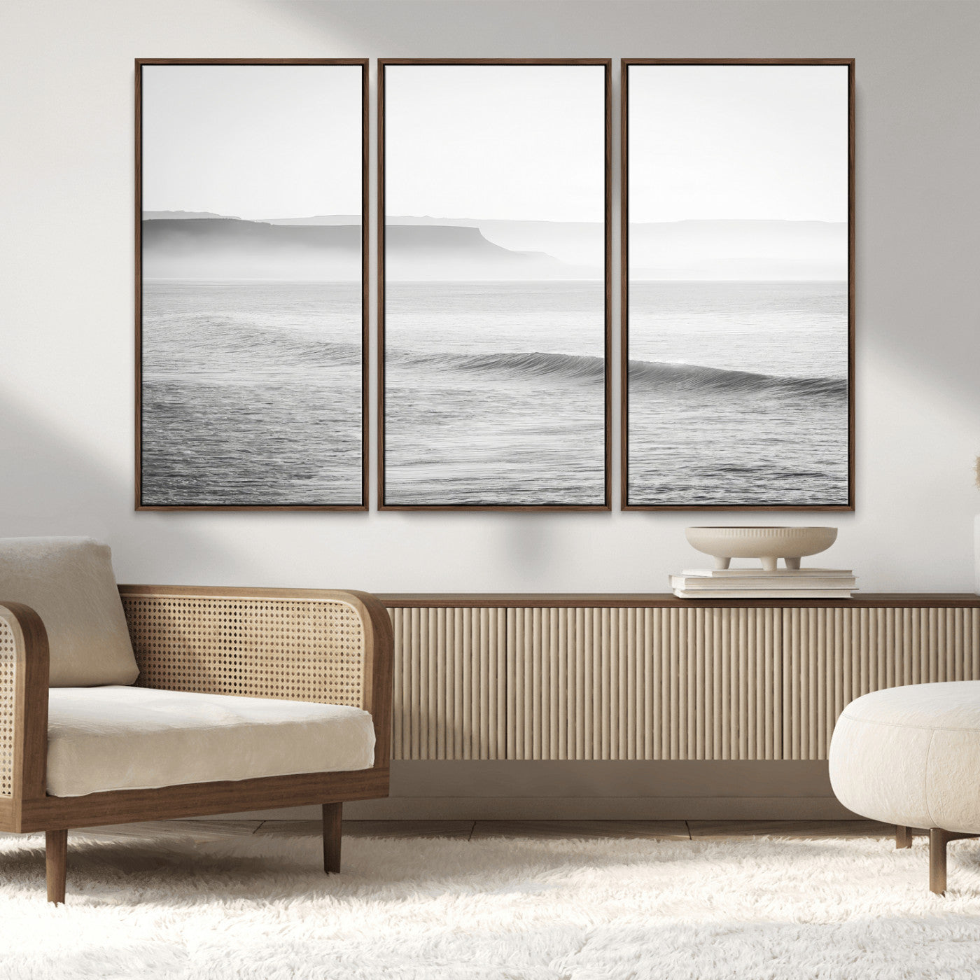 A black and white minimalist seascape featuring soft rolling waves and misty distant cliffs, creating a serene and timeless coastal atmosphere.