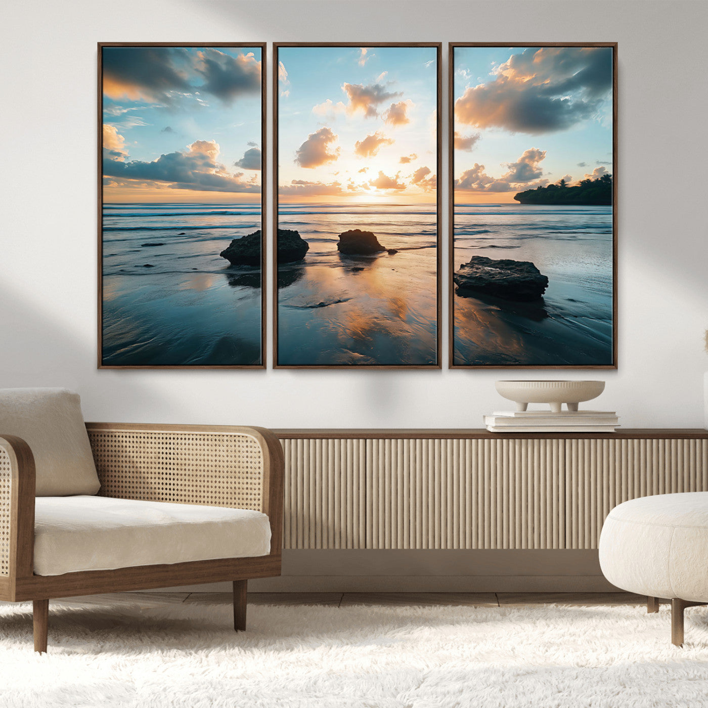 A serene beach at sunset with vibrant clouds, calm water, and rocks in the foreground reflecting the warm colors of the setting sun.