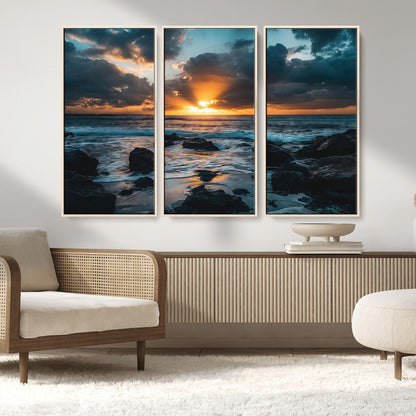 An awe-inspiring sunset over the ocean with rays of light piercing through dramatic clouds, creating a beautiful seascape with rocks in the foreground.