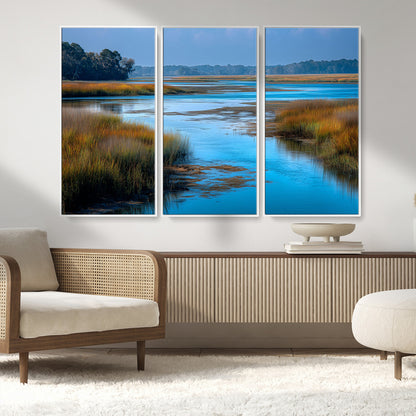 A peaceful marshland scene with calm blue water reflecting the surrounding grasses and trees, capturing the beauty of nature in a serene landscape.