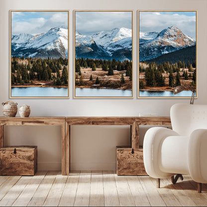 Framed canvas of snowy mountain peaks with pine forest and alpine lake, perfect for winter cabin or wilderness-inspired home decor.