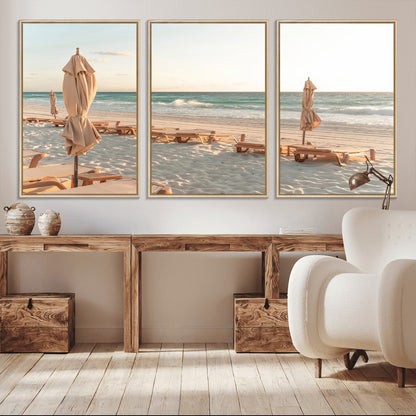 Minimalist photo of empty beach loungers and umbrellas on soft sand, ideal for calm seaside or pastel coastal-style home decor.