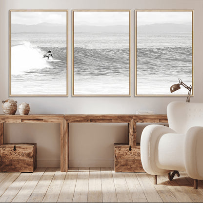 Monochrome photo of a surfer riding a wave with distant mountains, ideal for coastal motion or black and white surf-themed wall decor.