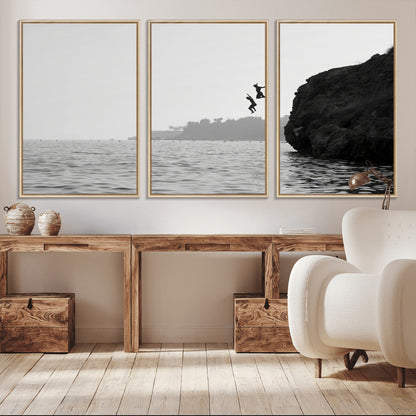 Black and white canvas of two figures cliff jumping into the sea, captured with moody tones, ideal for modern coastal or adventure-themed home decor.   2/2