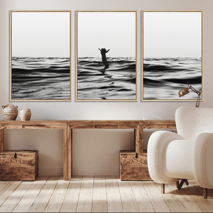 Black and white ocean with a hand making a surfer sign among dark waves, creating a dramatic and minimalist seascape with bold contrast.