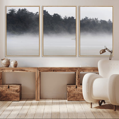 A lone surfer carrying a board through a misty shoreline, surrounded by dense trees and fog, creating a peaceful and mysterious coastal scene.
