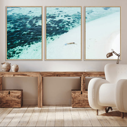 Canvas featuring an aerial view of a swimmer in shallow turquoise waters with coral patterns, ideal for tropical coastal home decor.