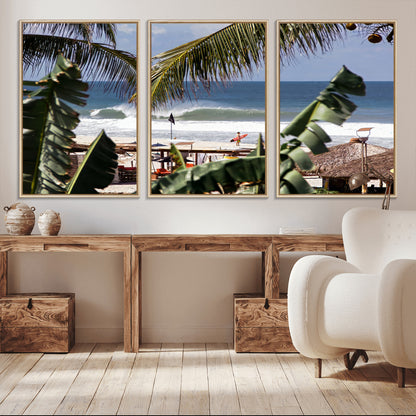 Canvas wall art of a tropical surf scene framed by palm trees, with a surfer on the shore and waves rolling in, ideal for beach-themed decor.
