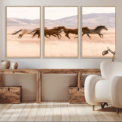 A herd of wild horses galloping through a sunlit desert plain with mountains in the background, perfect for rustic or western-themed wall decor.