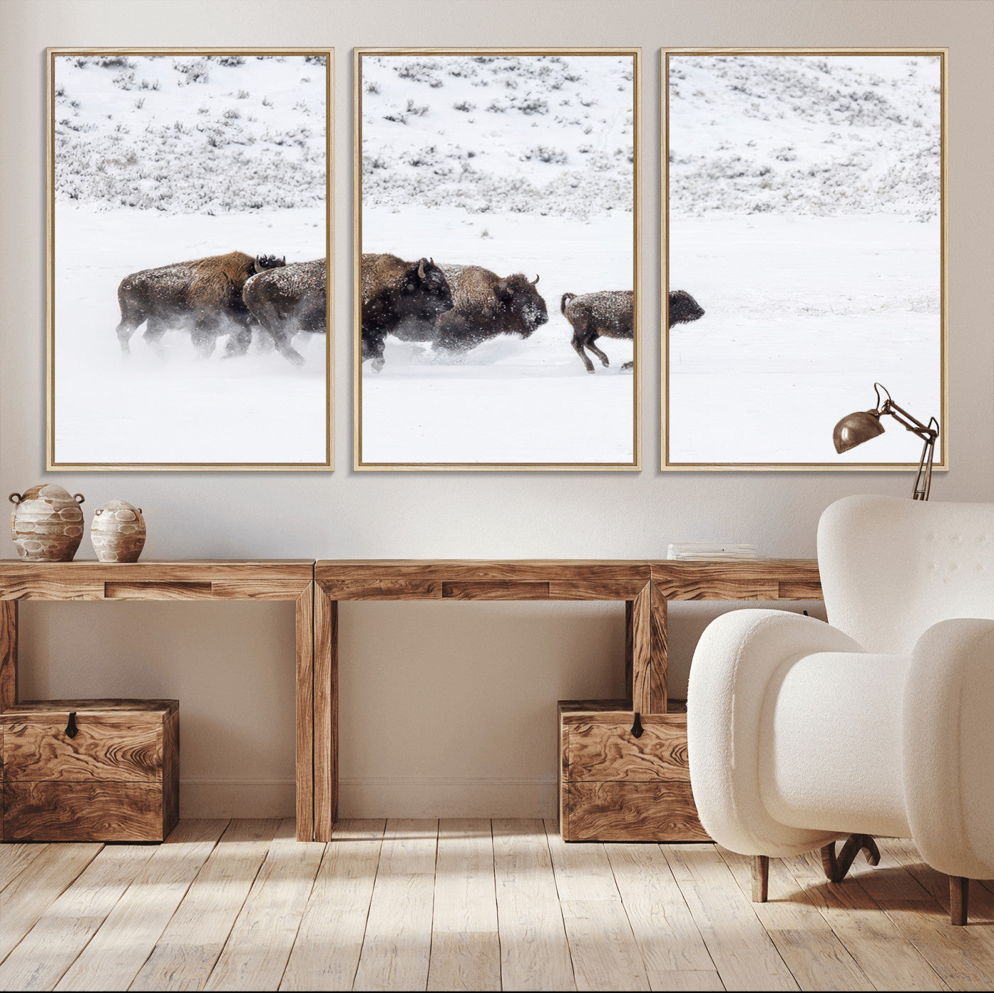 Bison herd running through a snowy open field with mountain backdrop, perfect for rustic or western-themed wall decoration.